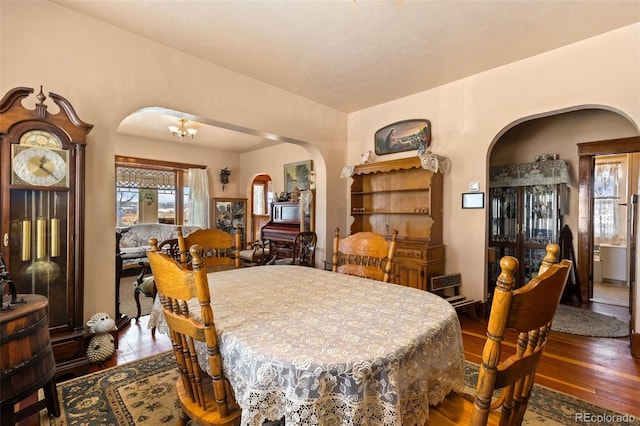 dining area with hardwood / wood-style flooring and an inviting chandelier