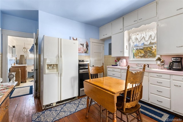 kitchen featuring decorative backsplash, white cabinetry, dark hardwood / wood-style flooring, and white fridge with ice dispenser