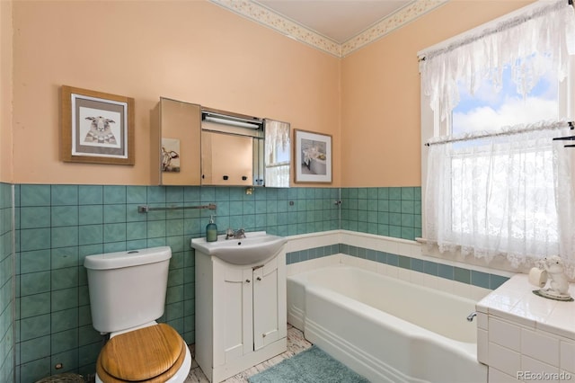 bathroom with a bathtub, toilet, tile walls, and vanity