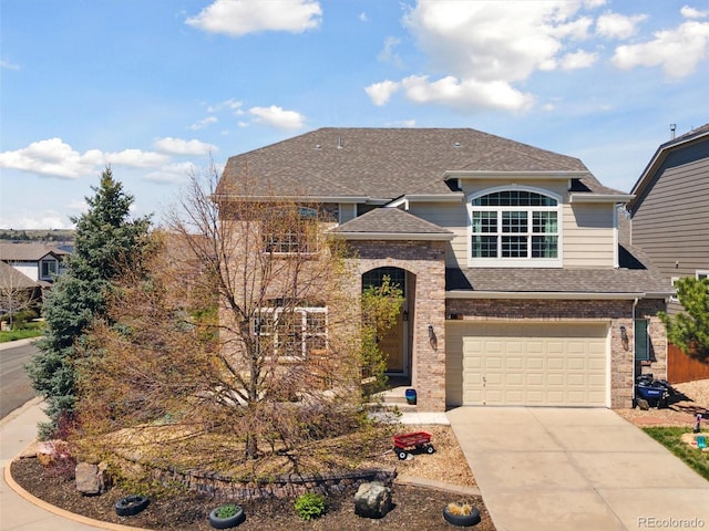 traditional home with roof with shingles, driveway, a garage, and brick siding