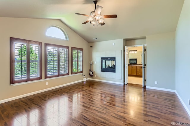 23029 Cleveland Dr, Parker, CO 80138 - unfurnished living room with ceiling fan, a tile fireplace, vaulted ceiling, and dark wood-style flooring