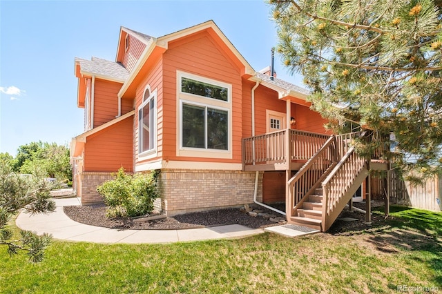 19595 N Mitchell Dr, Denver, CO 80249 - view of front of home with stairs, brick siding, a wooden deck, and a front lawn