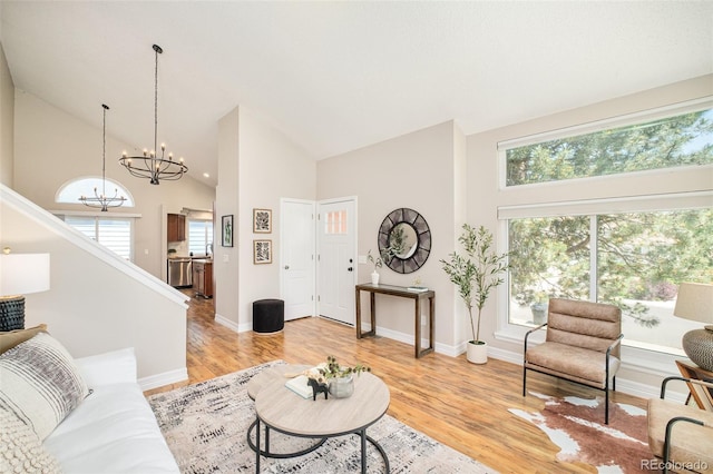 19595 N Mitchell Dr, Denver, CO 80249 - living area featuring high vaulted ceiling, a chandelier, plenty of natural light, light wood finished floors, and stairway