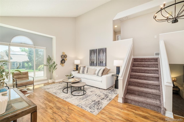 19595 N Mitchell Dr, Denver, CO 80249 - living room featuring stairs, high vaulted ceiling, wood finished floors, and a chandelier