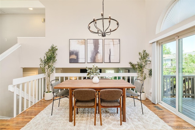 19595 N Mitchell Dr, Denver, CO 80249 - dining room with wood finished floors, a chandelier, and a towering ceiling