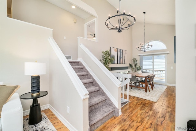 19595 N Mitchell Dr, Denver, CO 80249 - staircase featuring a chandelier, high vaulted ceiling, wood finished floors, and recessed lighting