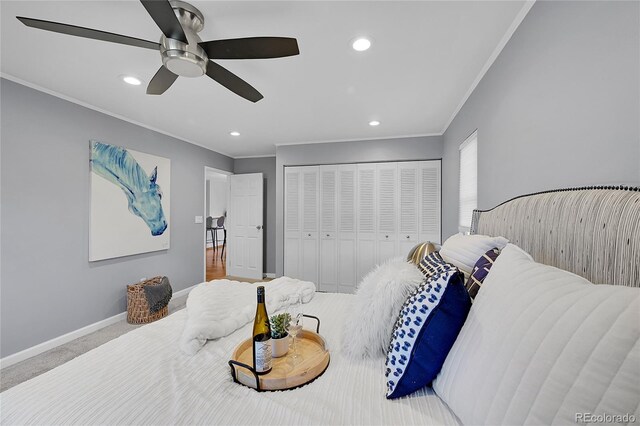 bedroom featuring a closet, ceiling fan, crown molding, and carpet flooring