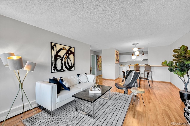 living room with a textured ceiling and light hardwood / wood-style floors