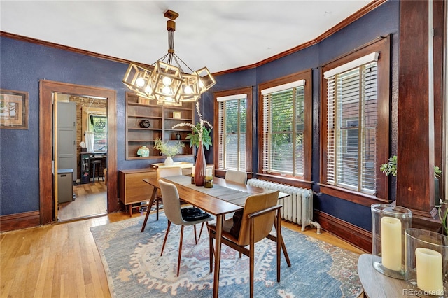 2236 Forest St, Denver, CO 80207 - dining room featuring baseboards, a chandelier, crown molding, wood finished floors, and radiator