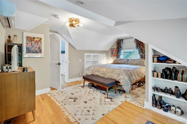 2236 Forest St, Denver, CO 80207 - bedroom featuring lofted ceiling, light wood-type flooring, baseboards, and a wall mounted air conditioner