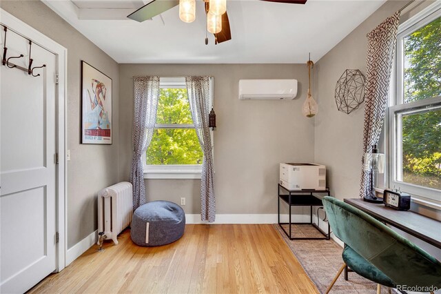 2236 Forest St, Denver, CO 80207 - living area with radiator heating unit, a wall mounted air conditioner, wood finished floors, a ceiling fan, and baseboards