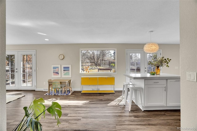 dining room featuring dark hardwood / wood-style floors, a textured ceiling, and french doors