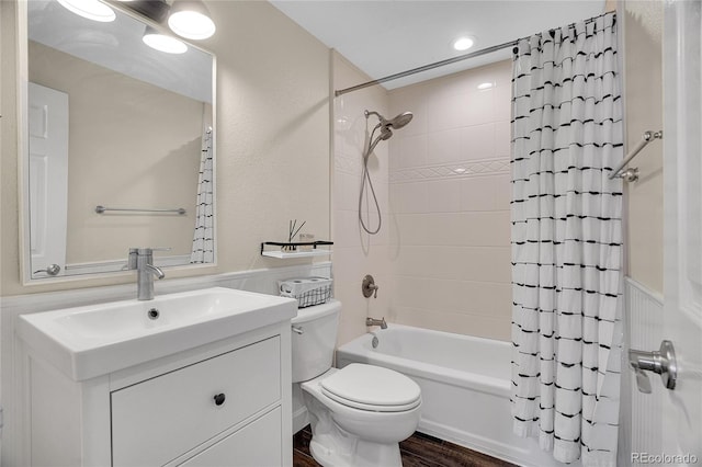 full bathroom featuring vanity, hardwood / wood-style flooring, shower / bath combo, and toilet