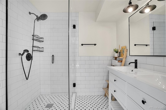 bathroom with vanity, a shower with door, and tile walls