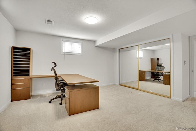 carpeted home office with a textured ceiling