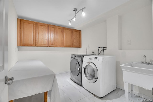 laundry area with rail lighting, sink, cabinets, washer and dryer, and light tile patterned floors