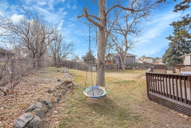 view of yard with a wooden deck and a trampoline