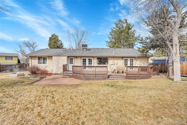 rear view of house featuring a wooden deck, a yard, and a patio