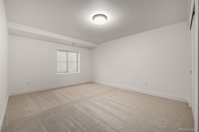 carpeted spare room featuring a textured ceiling