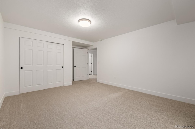 unfurnished bedroom with carpet floors, a closet, and a textured ceiling