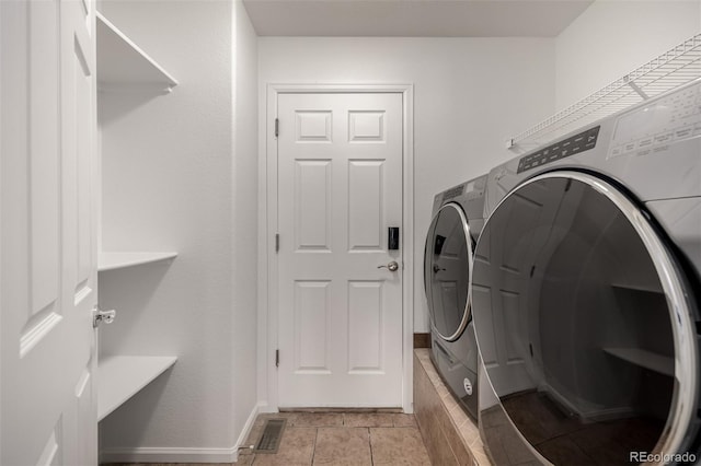 clothes washing area featuring washer and dryer and light tile patterned floors