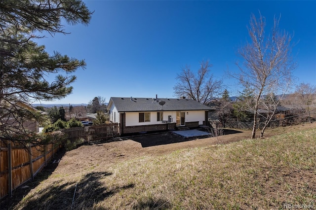 rear view of property featuring a patio area, brick siding, a fenced backyard, and a lawn