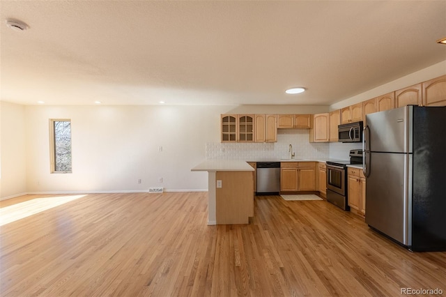 kitchen with a sink, stainless steel appliances, light wood finished floors, and light brown cabinets