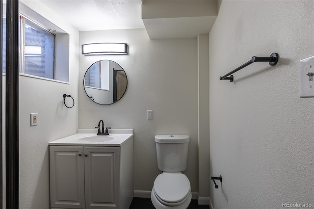 bathroom featuring vanity, toilet, and baseboards