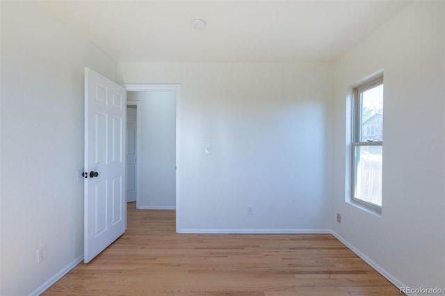 empty room with light wood-type flooring and baseboards