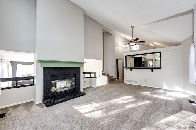 unfurnished living room featuring ceiling fan, high vaulted ceiling, a fireplace, and light colored carpet