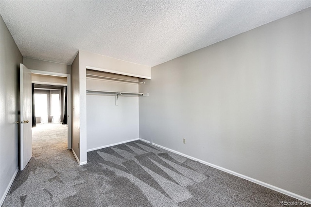 unfurnished bedroom featuring a closet, a textured ceiling, and dark carpet