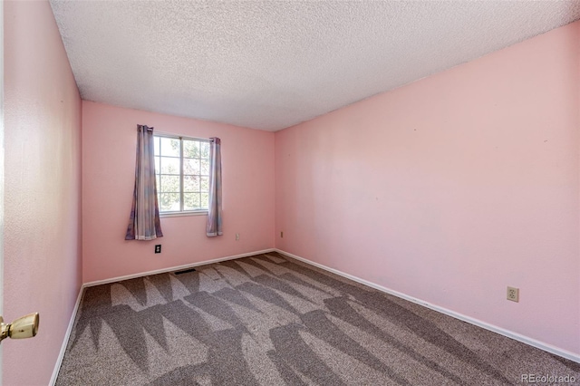 spare room featuring a textured ceiling and carpet floors