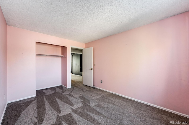 unfurnished bedroom featuring a closet, a textured ceiling, and dark carpet