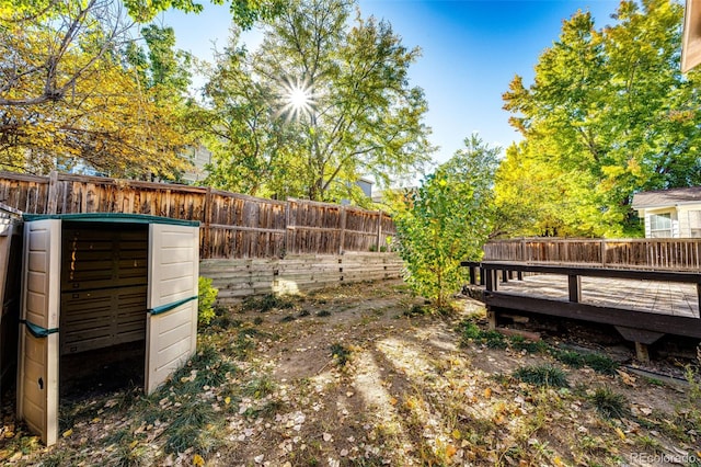 view of yard with a storage unit and a deck