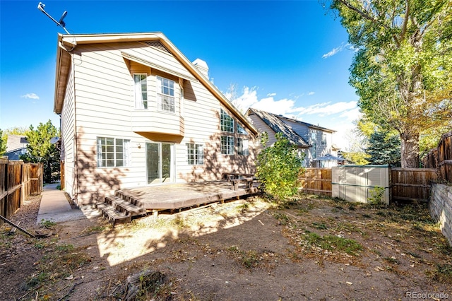 back of property featuring a shed and a deck