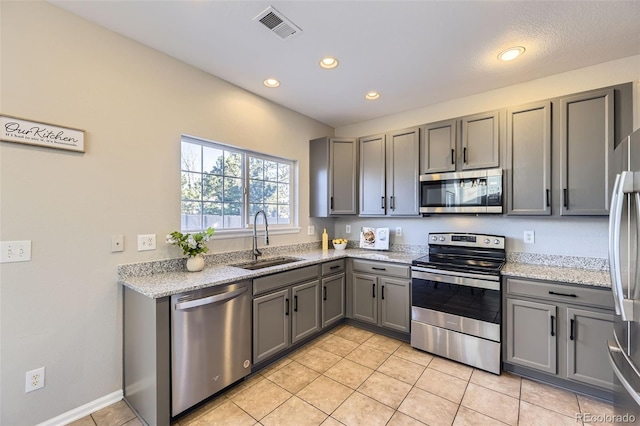 kitchen with a sink, gray cabinets, visible vents, and stainless steel appliances