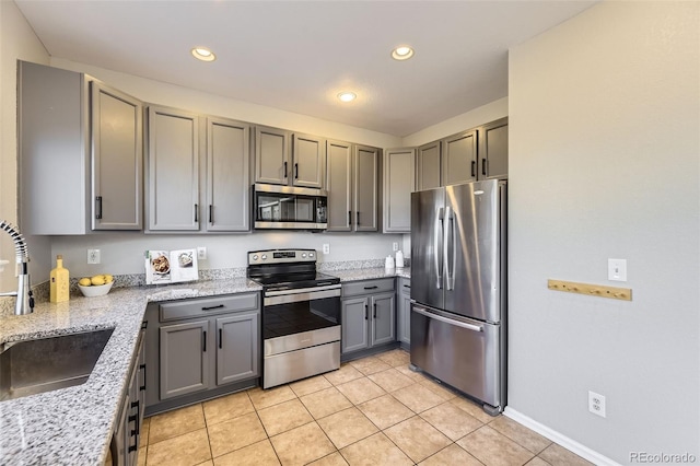 kitchen featuring light tile patterned floors, recessed lighting, gray cabinets, appliances with stainless steel finishes, and a sink