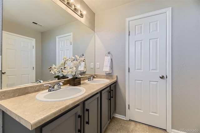 bathroom with tile patterned flooring, double vanity, visible vents, and a sink