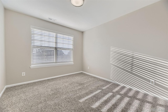 carpeted empty room with visible vents and baseboards