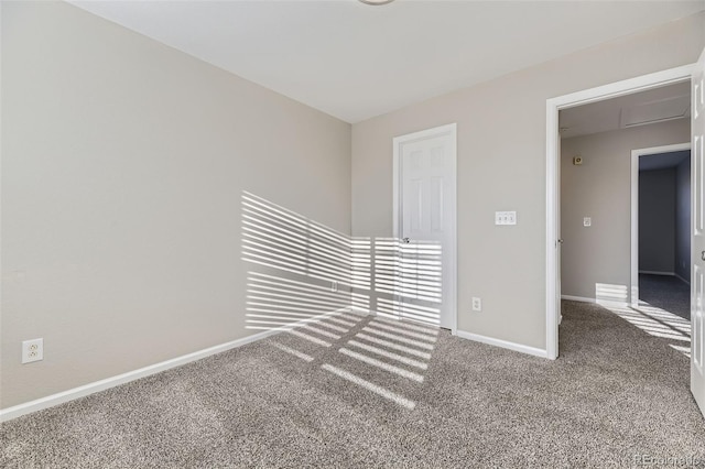 carpeted empty room featuring baseboards