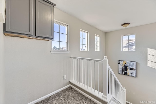 stairs featuring carpet flooring and baseboards