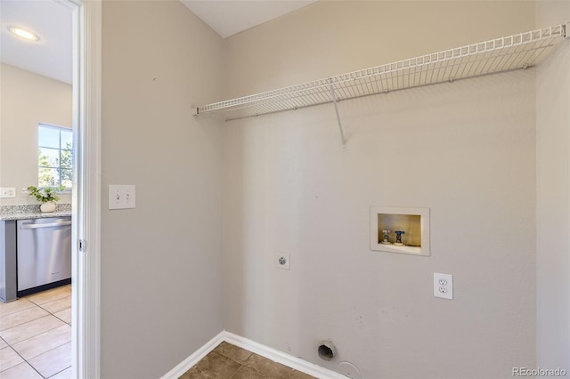 clothes washing area with electric dryer hookup, light tile patterned floors, baseboards, hookup for a washing machine, and laundry area