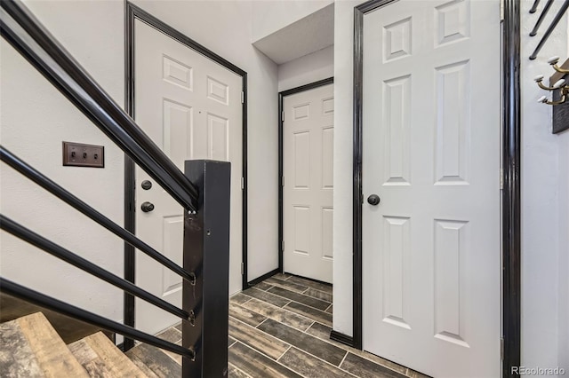 foyer with stairs, wood finish floors, and baseboards