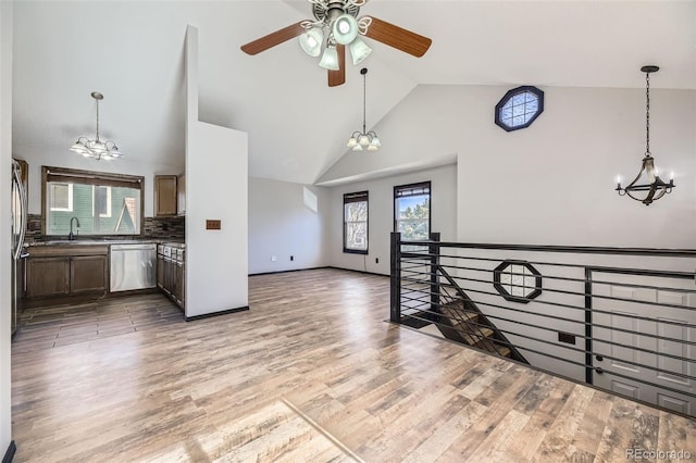 kitchen featuring a chandelier, stainless steel dishwasher, open floor plan, and wood finished floors