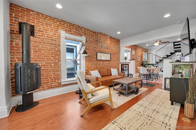 1208 S Pennsylvania St, Denver, CO 80210 - living room featuring brick wall, stairs, healthy amount of natural light, wood finished floors, and a ceiling fan