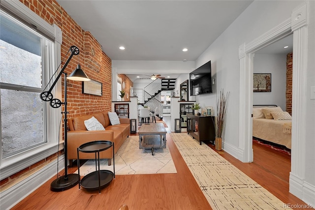 1208 S Pennsylvania St, Denver, CO 80210 - living room featuring stairway, light wood-style floors, brick wall, a ceiling fan, and baseboards