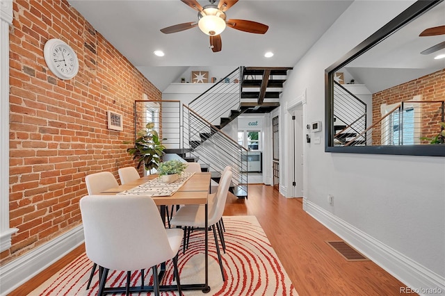 1208 S Pennsylvania St, Denver, CO 80210 - dining space featuring ceiling fan, stairs, brick wall, wood finished floors, and baseboards