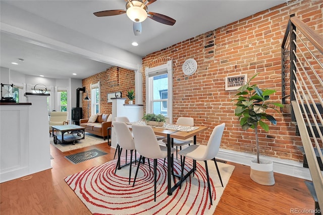 1208 S Pennsylvania St, Denver, CO 80210 - dining space featuring brick wall, healthy amount of natural light, a ceiling fan, wood finished floors, and stairs