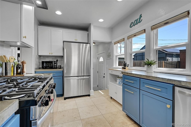 1208 S Pennsylvania St, Denver, CO 80210 - kitchen featuring appliances with stainless steel finishes, blue cabinets, white cabinets, and recessed lighting