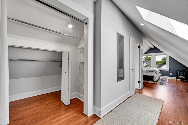 1208 S Pennsylvania St, Denver, CO 80210 - hall featuring a skylight, lofted ceiling, wood finished floors, and baseboards